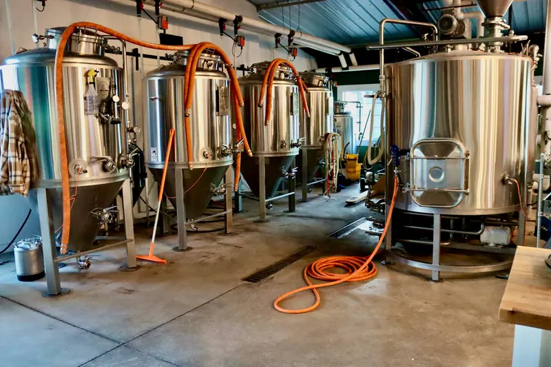 Stainless steel processing tanks and piping inside an industrial facility