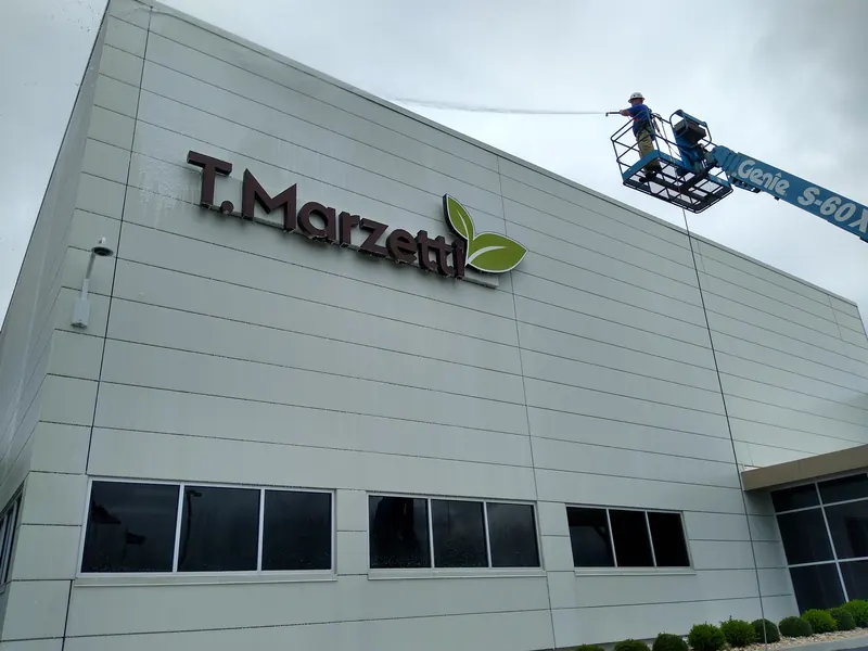 Shine Brite crew on a lift washing the wall of a food manufacturing plant